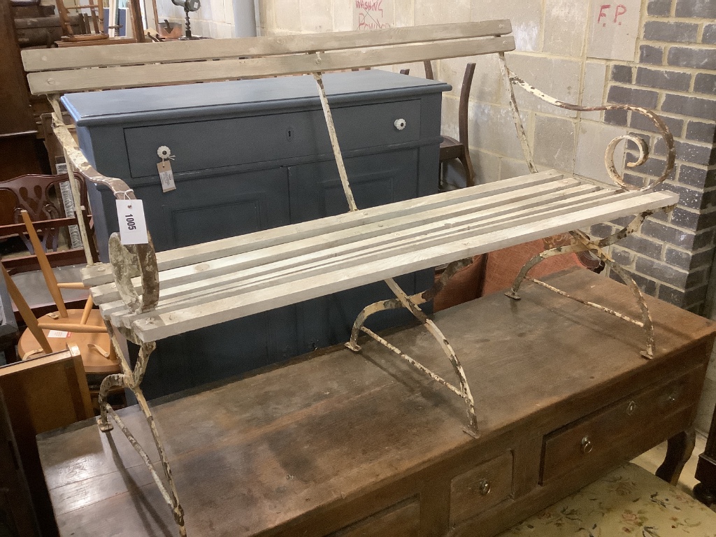 A white painted wrought iron garden seat with wooden slatted seat, width 121cm